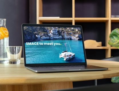 Schermata laptop con logo Smace e gommone in mare cristallino